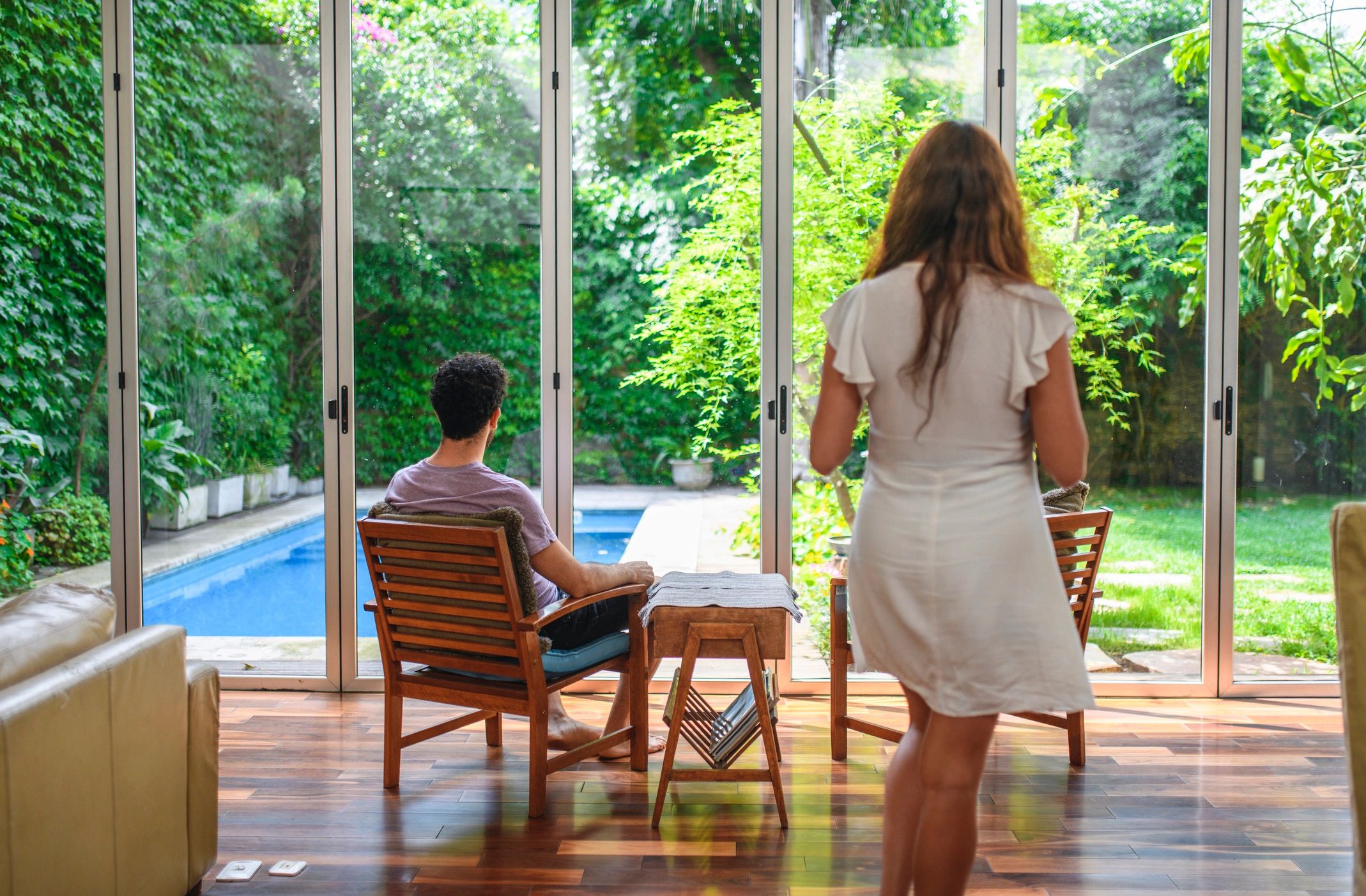Couple relaxing in a naturally lit sitting area with terrace view