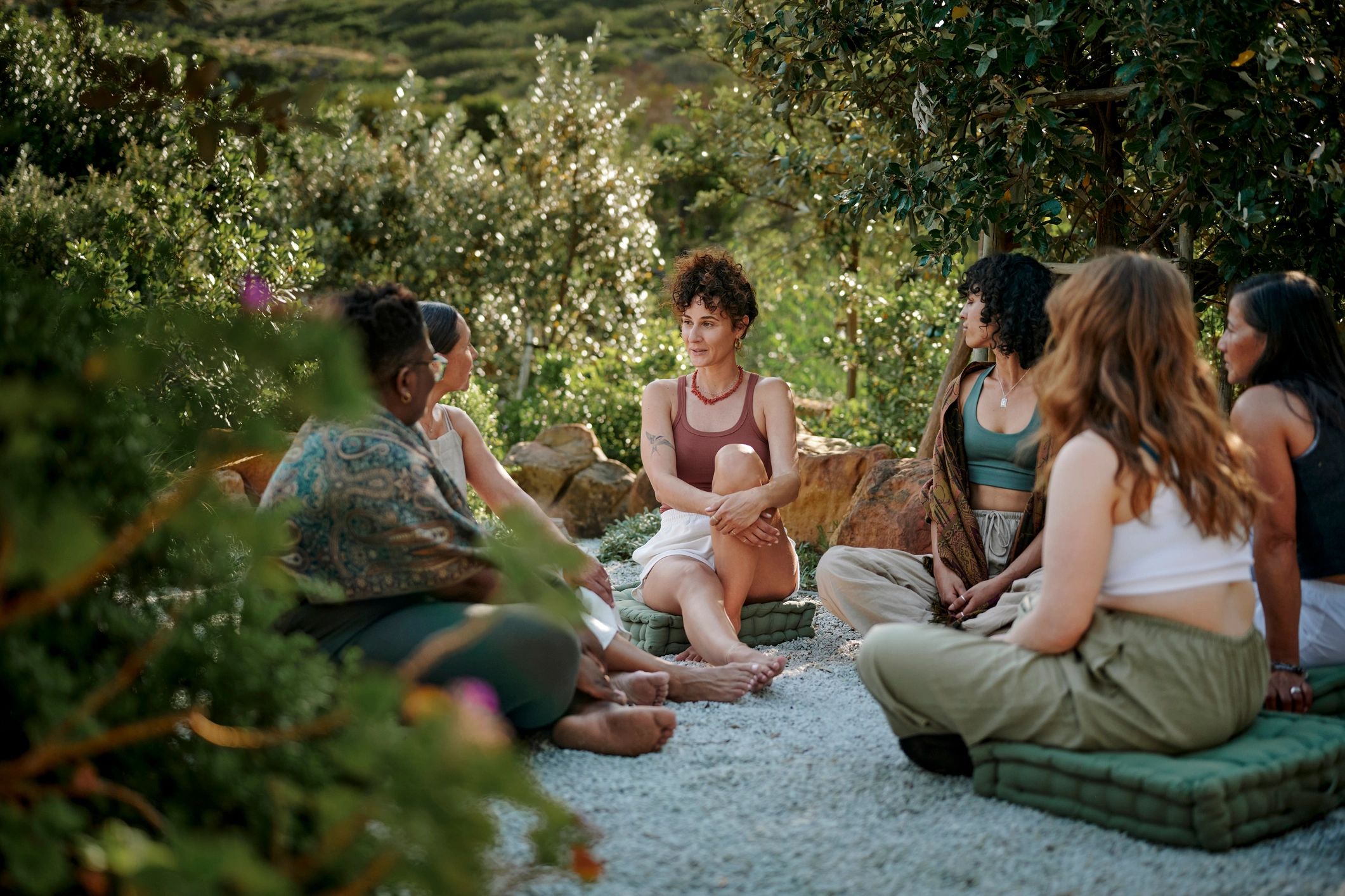 Small group conversation outdoors at a wellness setting