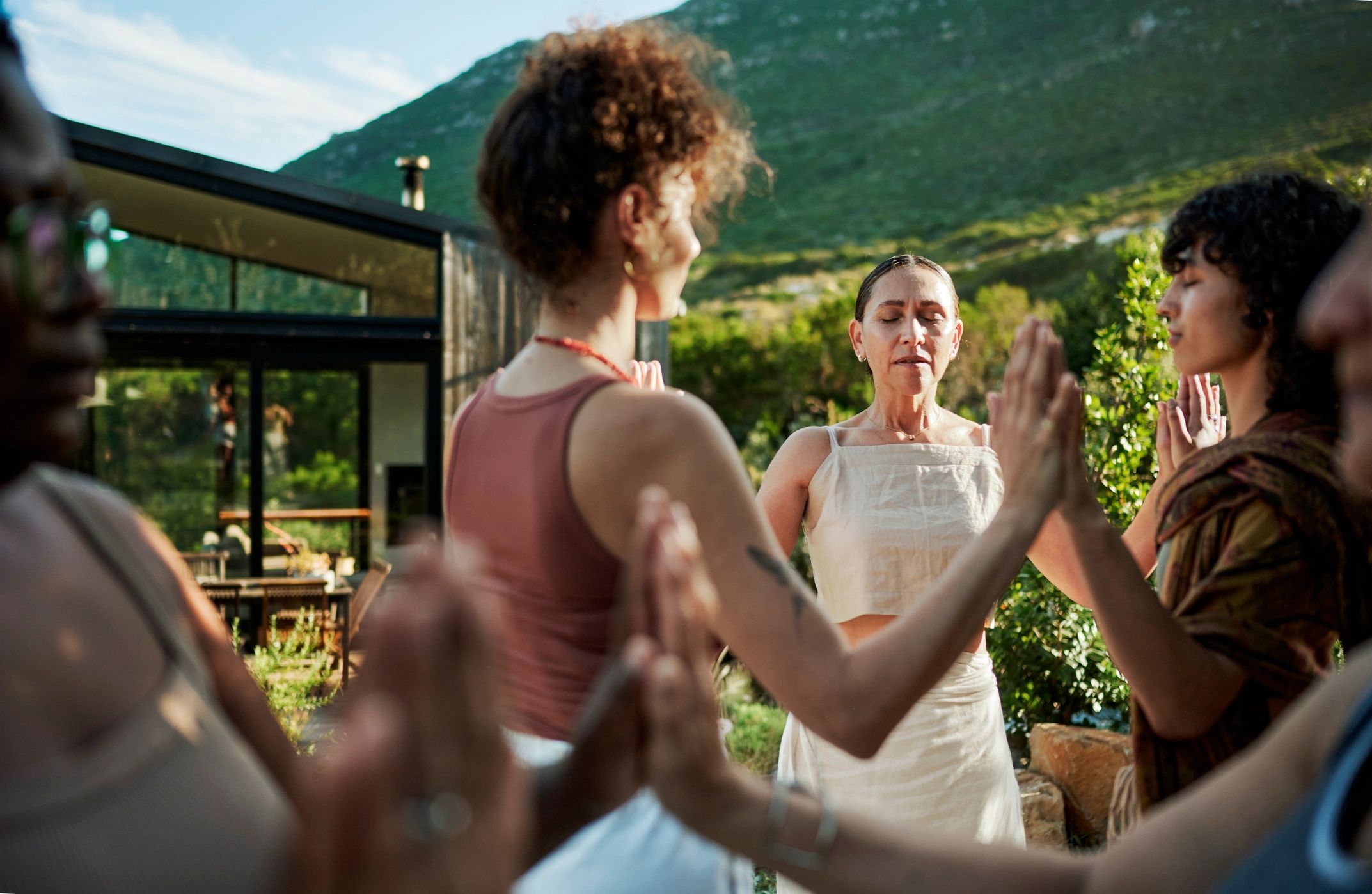 Adults participating in a guided wellness exercise outdoors at a retreat