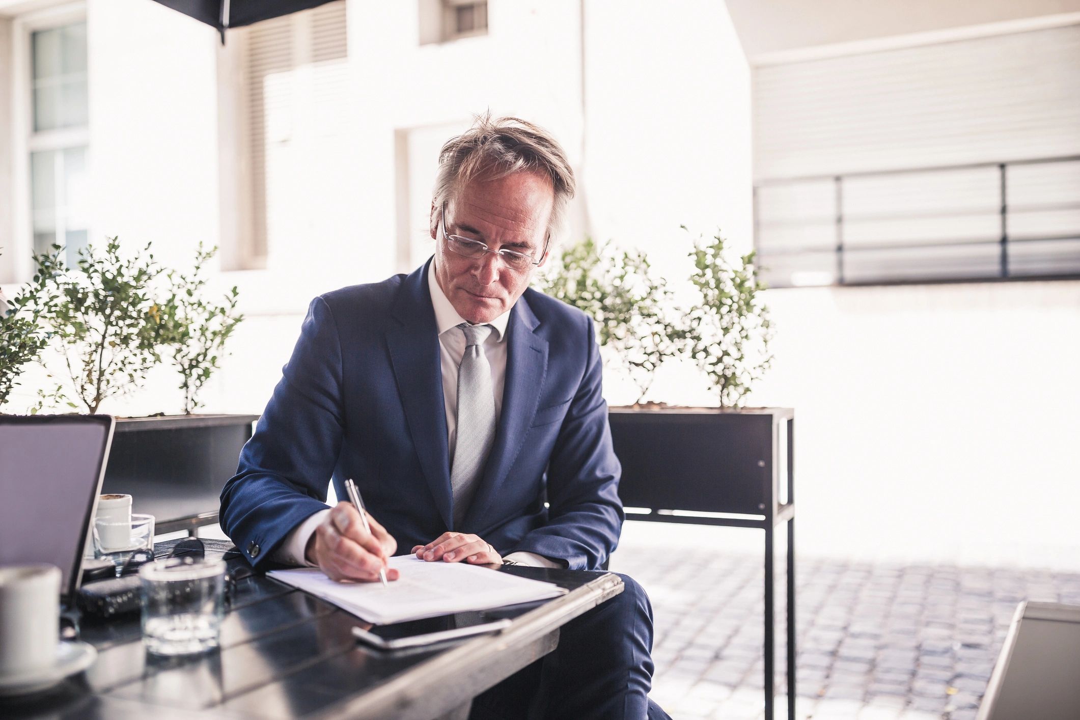 Business professional writing outdoors on a quiet terrace