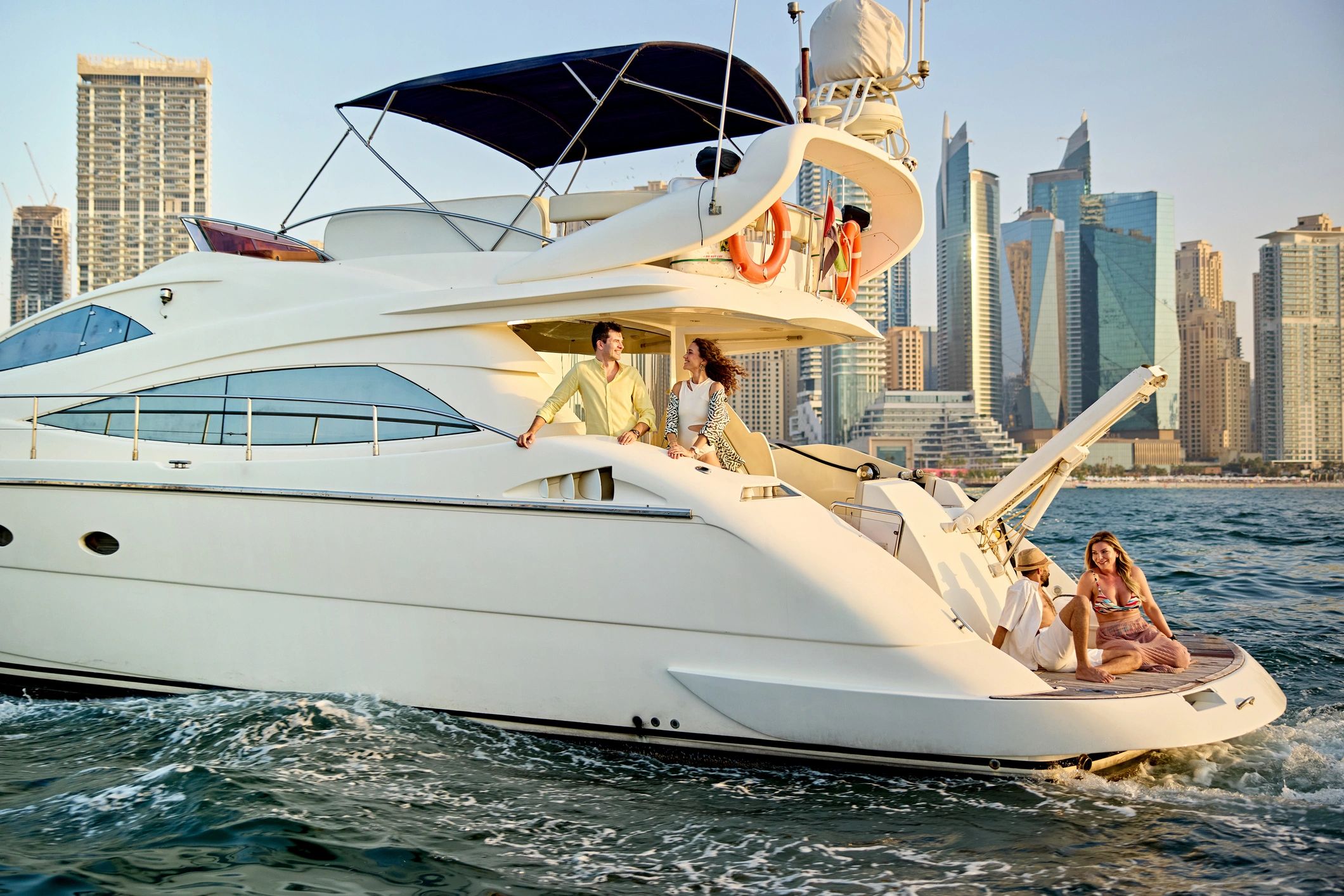 Friends relaxing on a luxury yacht with city skyline in the background