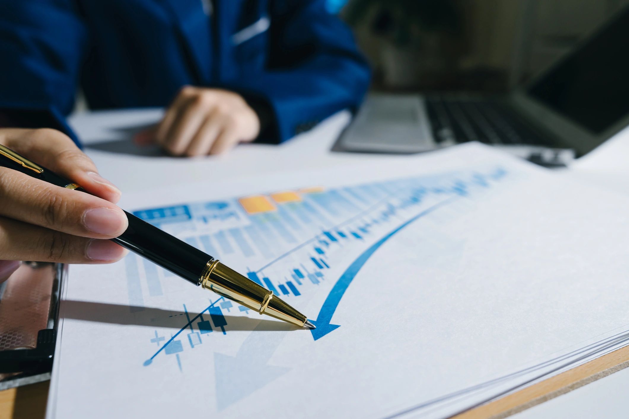 Hand pointing at financial chart showing growth