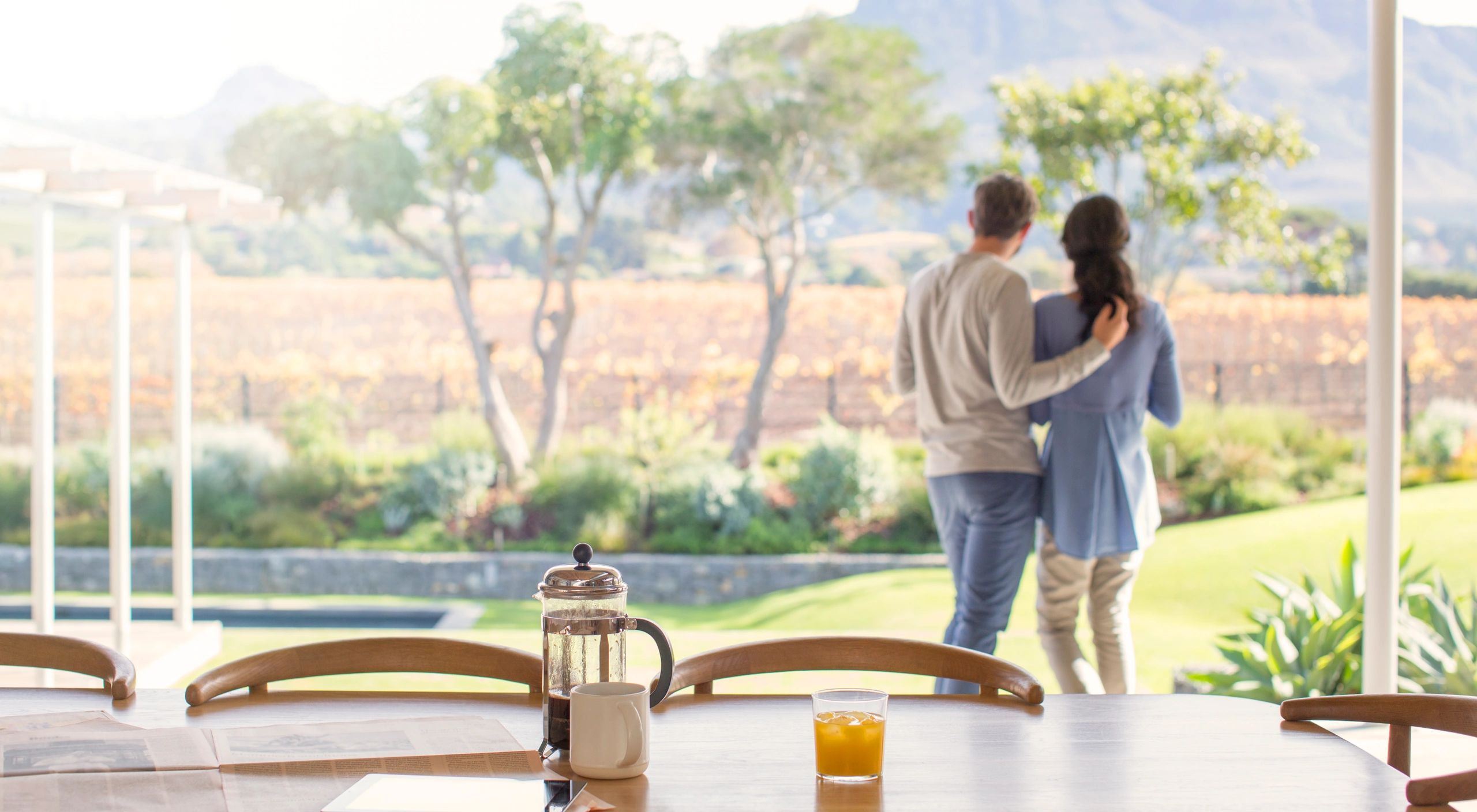 Couple embracing on a terrace overlooking a serene landscape during a retreat
